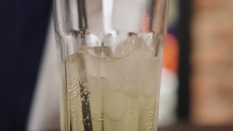 Close-up-of-beverage-in-glass-cup-with-ice-cubes,-drink-beverage-with-straw