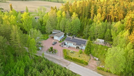 Aerial-view-circling-a-sunlight-powered-house-with-a-EV-car-charging-on-the-yard