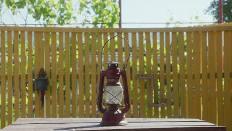 A-Woman-Places-the-Old-Vintage-Kerosene-Lantern-on-the-Table---Static-Shot