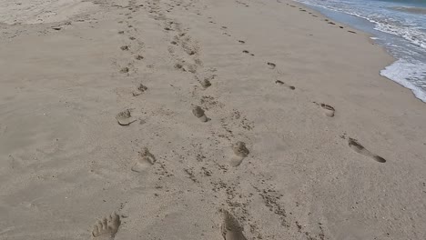 Trails-of-footprints-in-soft-sand-on-the-beach