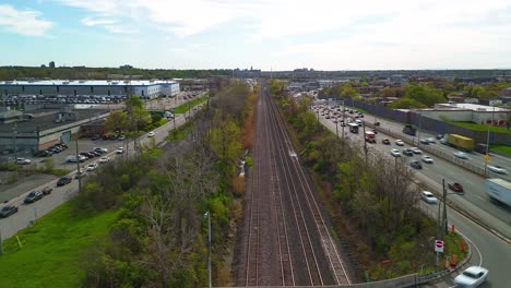 Drones-Aéreos-De-Hiperlapso-Sobrevuelan-Con-Tráfico-Ferroviario-Y-De-Automóviles-Conduciendo-En-Horas-Pico-En-El-área-Suburbana-Metropolitana-De-La-Gran-Ciudad-Moderna,-Concepto-De-Contaminación-Del-Aire