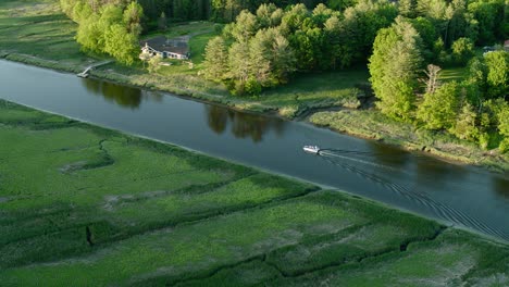 Drone-shot-of-a-pontoon-boat-cruising-down-the-tidal-Squamscott-river-in-Stratham,-NH