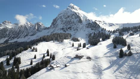 Avión-Teledirigido-Que-Se-Mueve-Hacia-Atrás-Sobre-Una-Cordillera-Cubierta-De-Nieve-En-Fronalpstock,-Suiza,-Glarus,-En-Un-Frío-Día-De-Invierno