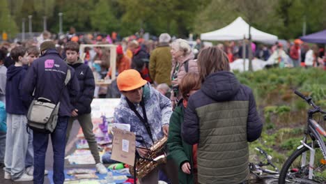 Child-with-saxophone-and-friends-in-a-Dutch-park-during-Kingsday-in-Amsterdam