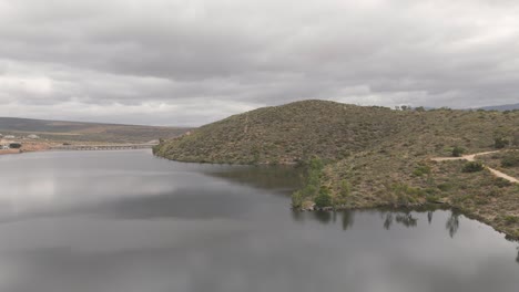 Drone-shot-of-a-dam-in-Grabouw,-Cape-Town-trimmed-with-mountains-that-surround-it
