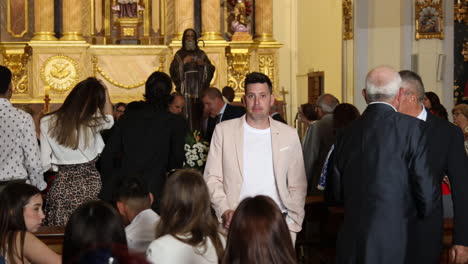 Personas-Reunidas-Para-Una-Ceremonia-En-Una-Iglesia-Española,-Luz-Filtrándose,-Ambiente-Solemne