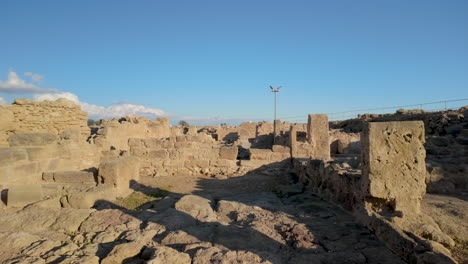 Weathered-stone-ruins-and-pathways-at-the-Kato-Pafos-archaeological-site,-hinting-at-the-layout-of-ancient-buildings