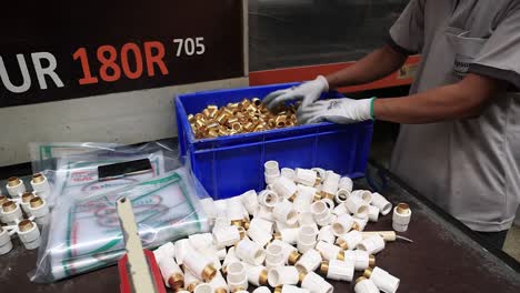 pov-shot-The-copper-metal-joints-made-in-the-machine-are-being-stored-in-a-large-container