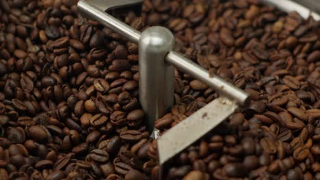 Roasted-Coffee-Beans-Rotating-In-Stainless-Steel-Roaster-Machine,-Close-Up