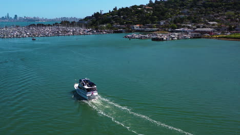 Aerial-view-around-a-boat-in-front-of-the-Sausalito-town,-in-sunny-California,-USA