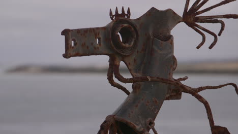 abstract-art-of-a-sea-horse-made-from-scrap-metal-pieces-overlooking-the-water