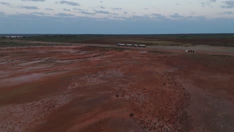 Drohnenclip,-Der-Einen-LKW-Mit-Mehreren-Waggons-Zeigt,-Der-Auf-Einer-Geraden-Straße-Durch-Das-Australische-Outback-Fährt
