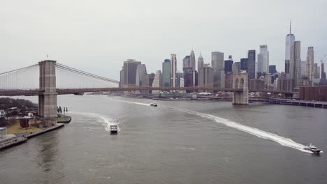 Entire-Brooklyn-Bridge-From-Aerial-View-With-Boats-In-East-River-In-Slow-Motion