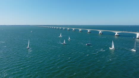 Sailboats-passing-through-the-Zeeland-bridge-during-a-sunny-windy-day
