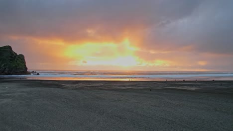 Piha-Beach-Bei-Sonnenuntergang-An-Der-Küste-Der-Tasmansee-In-Auckland,-Neuseeland