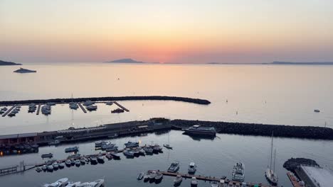 Puesta-De-Sol-Sobre-El-Impresionante-Puerto-Deportivo-De-Piano-Di-Sorrento,-Cerca-De-La-Costa-De-Amalfi,-Italia,-Mientras-El-Ardiente-Sol-Se-Esconde-Bajo-El-Horizonte,-Pintando-El-Cielo-Con-Vibrantes-Tonos-Naranjas.