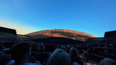 People-sitting-in-large-immersive-theater-to-watch-nature-film-on-curved-screen