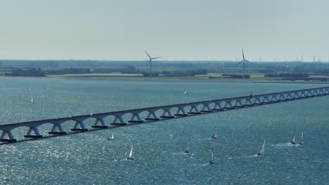 Drohnenaufnahme-Der-Zeelandbrücke-Mit-Langer-Brennweite-Und-Vielen-Vorbeifahrenden-Segelbooten