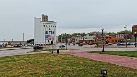 Ardent-Mill-in-Alton-with-Welcome-to-Alton-Facade-and-American-Flag-Mural,-Traffic-Flowing-at-Intersection,-Illinois,-USA