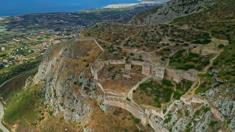 Drones-Aéreos-Avanzando-Sobre-El-Icónico-Sitio-Arqueológico-De-La-Antigua-Corinto-Construido-A-Lo-Largo-De-La-Ladera-De-Acrocorinto,-Peloponeso,-Grecia-En-Un-Día-Nublado