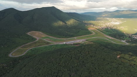 Aerial-Pan-Over-Salta,-Argentina's-Forested-Mountain-Ractrack,-Autódromo-Martín-Miguel-de-Güemes