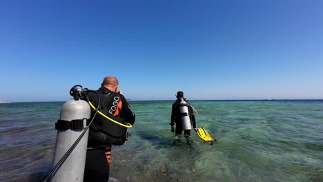 Elder-caucasian-men-walk-enters-the-ocean-for-diving-at-Egyptian-blue-sea-slow