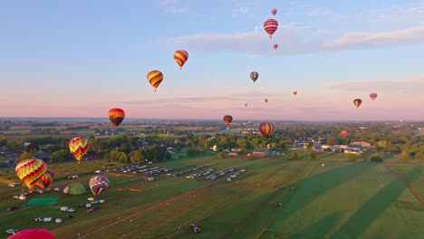 A-fleet-of-vibrant-hot-air-balloons-rises-gently-into-a-warm-sunset-sky-above-a-serene-rural-landscape