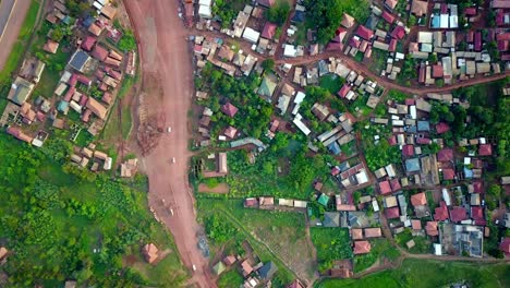 Kampala-Entebbe-Expressway,-Uganda,-East-Africa---Cars-Traveling-Along-the-Bustling-Highway-Near-a-Residential-Community---Bird's-Eye-View