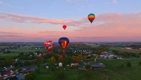 Colorful-hot-air-balloons-soar-over-a-tranquil-landscape-bathed-in-the-soft-light-of-an-early-autumn