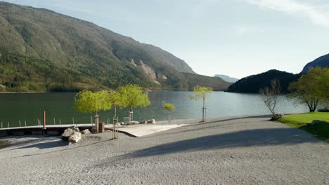 Tranquil-view-of-Lake-Molveno-surrounded-by-lush-mountains,-featuring-a-serene-waterfront-and-vibrant-green-trees