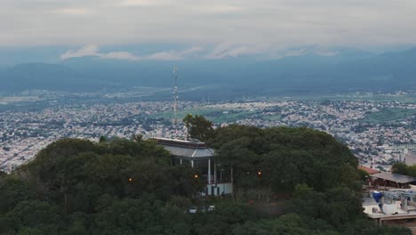 Aufsteigende-Antenne-Zeigt-Die-Hauptstadt-Salta-Hinter-Dem-Berggipfel