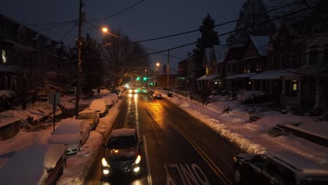 Low-aerial-shot-above-card-driving-on-plowed-and-salted-road-in-American-city-after-snow-storm