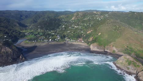 Luftaufnahme-Von-Piha-Beach,-Lion-Rock-Und-Taitomo-Island-Am-Blauen-Meer-Im-Westen-Von-Auckland,-Neuseeland