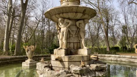 We-see-with-a-camera-elevation-in-the-Jardines-de-el-Principe-the-impressive-fountain-of-Narcissus-located-in-a-small-square-of-sand-with-an-environment-of-trees-we-see-Narcissus-inside-a-platform