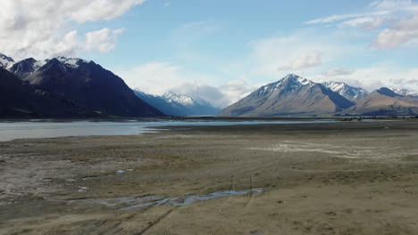 Aerial-Wide-Shot-Of-Godley-River-In-New-Zealand-With-Mountains-Far-Away,-Low-Tide-Glacial-Meltwater
