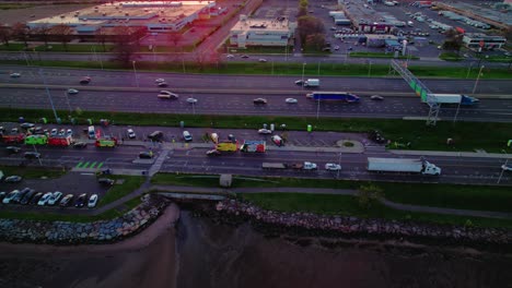 Aerial-of-food-trucks-gathering-along-a-busy-highway-in-New-Haven,-Connecticut-at-sunset,-creating-a-vibrant-street-food-scene