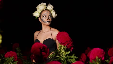 Mexican-female-model-in-catrina-costume,-modeling-in-the-middle-of-a-flower-field