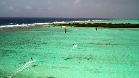 Kite-surfers-gliding-over-the-vibrant-turquoise-waters-of-buchillaco,-los-roques,-aerial-view