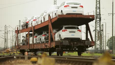 New-cars-transported-by-rail-on-a-multilevel-freight-train-car-at-a-railway-yard