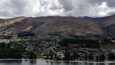 Luftaufnahme-Von-Wanaka,-Neuseeland,-Malerische-Schönheit,-Das-Ruhige-Wasser-Des-Sees-Trifft-Auf-Eine-Lebendige,-üppige-Stadt