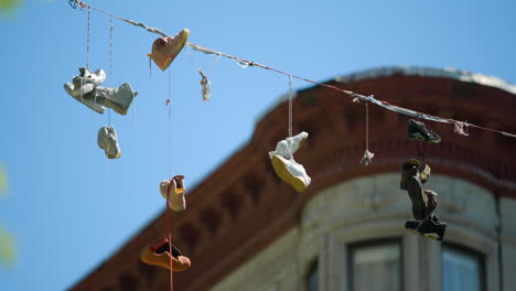 Several-Pair-of-Sneakers-Dangle-from-Wire-on-a-Sunny-Day-in-New-York-City