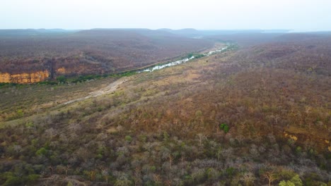 Aerial-drone-shot-of-parwati-river-covered-with-dense-semi-arid-forest-and-hills-around-it-in-shivpuri-area-of-Madhya-Pradesh-India