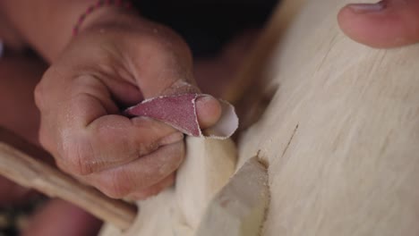 Carvers-Hand-With-Sandpaper-Sanding-The-Barong-Bangkal-Mask