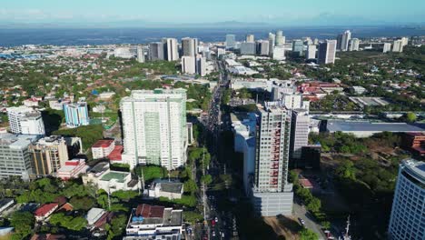 Aerial-forward-of-bustling-Philippine-city-with-corporate-buildings-and-busy-highway-in-Alabang,-Muntinlupa