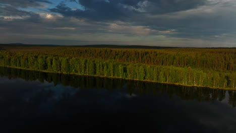 Aerial-view-of-layers-of-reflecting-water,-hills-and-Taiga-forest-of-Lapland
