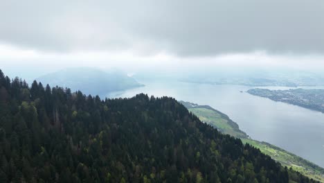 Aerial-revealing-shot-of-Weggis-town-and-Vierwaldstättersee-Lake-during-cloudy-day-in-Switzerland
