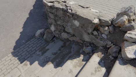 Muro-De-Piedra-Colapsado-En-La-Ciudad-Junto-A-Losas-De-Hormigón,-Infraestructura-Mal-Mantenida,-Cerrar