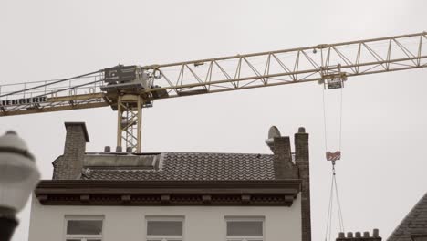 Construction-crane-operating-above-urban-building-rooftops