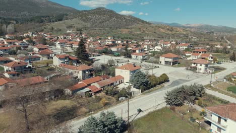 Drone-orbit-flight,-above-a-village-in-Europe,-green-hills,-red-roof-tops,-little-houses,-sunny-weather,-4K-video