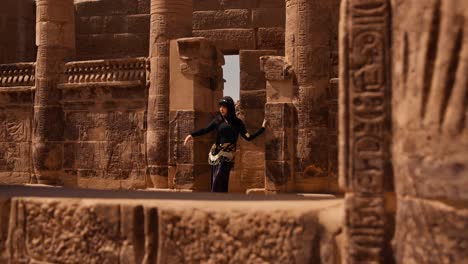 Girl-with-long-black-hair-and-Egyptian-style-outfit-in-Philae-temple-complex